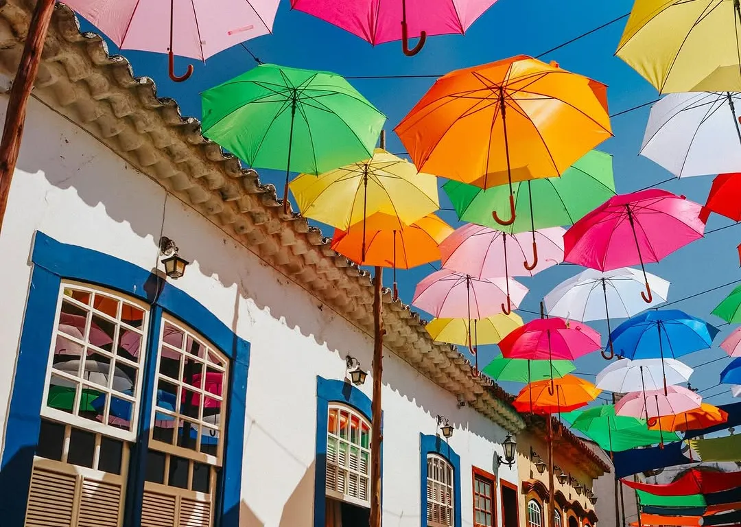 Rua decorada com guarda-chuvas coloridos durante o Carnaval